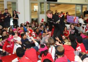 Canadian ski racer Kelby Halbert high-fives children from Our Lady of the Assumption school at Calgary Olympic Park on Monday. (photo: CAST)