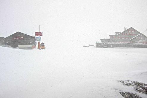 Snow falling in Engelberg, Switzerland, with view of two mountain buildings in the distance – Weather to ski – Snow report, 22 November 2024